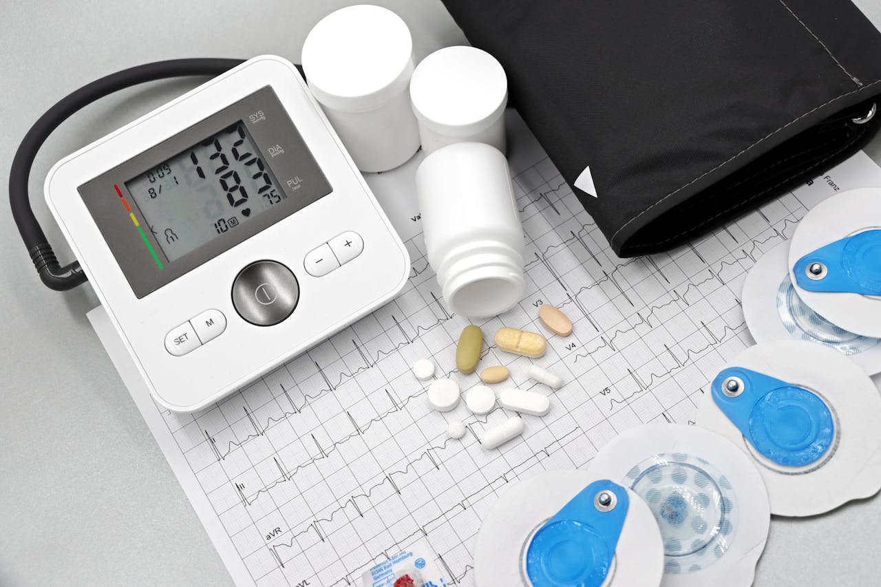 Product Flat lay of blood pressure monitor, pills, and ECG printout for heart health theme.